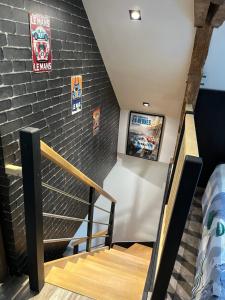 a staircase in a room with a brick wall at Logement indépendant à la campagne proche du Pôle européen du Cheval et Circuit des 24h du Mans in Courceboeufs