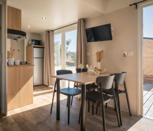 a kitchen and dining room with a table and chairs at Camping & Bungalows Platja Brava in Pals