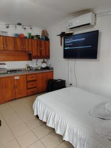 a bedroom with a bed and a tv on the wall at Hotel Piedra del Mar in Puerto López