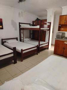 a room with two bunk beds and a kitchen at Hotel Piedra del Mar in Puerto López +40 photos