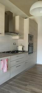 a kitchen with white cabinets and a stove top oven at Casa Serena in Carrara