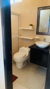 a bathroom with a toilet and a sink at Habitaciones privadas in Puerto Villamil +27 photos