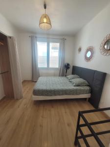 a bedroom with a bed and a window at JMAM Urban Suite T2 Climatisé en centre ville proche plage in Fos-sur-Mer +2 photos