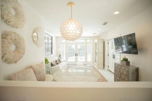 a living room with a chandelier and a table at Marée Mason in Ocean Springs
