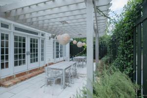 a patio with a table and chairs under a pergola at Marée Mason in Ocean Springs