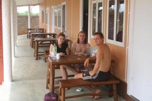 drie personen aan een tafel met een laptop bij The Long Hostel in Arugam Bay