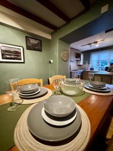 a dining room table with plates and wine glasses at Snowdon Retreat in Llanberis +11 photos