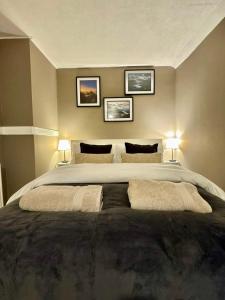 a large bed in a bedroom with three pictures on the wall at Snowdon Retreat in Llanberis
