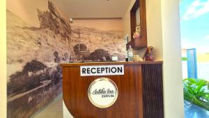 a reception desk in a building with a sign on it at Antilia Inn in Badami