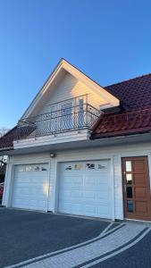 a house with two garage doors and a balcony at Veløyveien 4b in Sandefjord