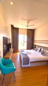 a bedroom with a large bed and a blue chair at Antilia Inn in Badami