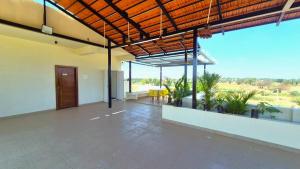 a large room with a patio with tables and chairs at Antilia Inn in Badami