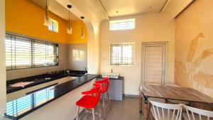 a kitchen with red stools and a long counter at Antilia Inn in Badami