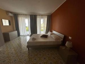 a bedroom with a bed and a large window at Thalore room e apartments in Amantea
