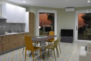 a kitchen and dining room with a table and chairs at Thalore room e apartments in Amantea