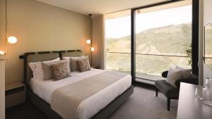 a bedroom with a bed and a large window at Quinta Vale de Lobos in Folgosa