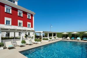 a hotel with a swimming pool next to a red building at Hotel Villa Garden in Sant'Agnello