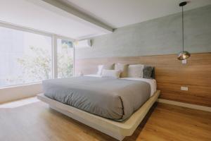 a bedroom with a large bed with a large window at Casa Palma in Medellín +44 photos