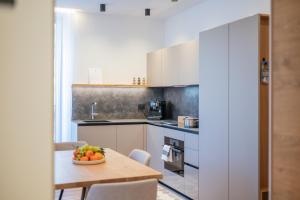 a kitchen with a table with a bowl of fruit on it at Apartament Tre Cime in San Sigismondo