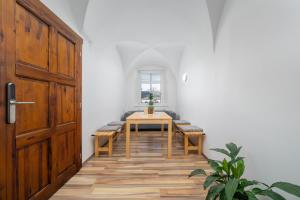 a room with a table and benches and a door at Penzion, restaurant Gloria in Chrastava