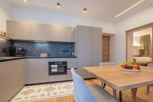 a kitchen and dining room with a wooden table and chairs at Apartament Tre Cime in San Sigismondo