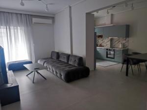ein Wohnzimmer mit Ledersofa und einem Tisch in der Unterkunft Urban Elegance in Larisa