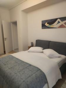 ein Schlafzimmer mit einem großen weißen Bett und zwei Kissen in der Unterkunft Urban Elegance in Larisa