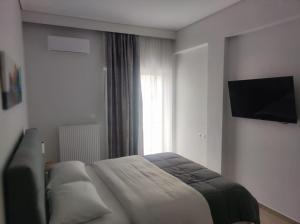 ein Schlafzimmer mit Bett und Flachbildfernseher in der Unterkunft Urban Elegance in Larisa