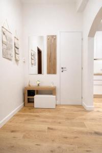 a white room with a white door and a wooden floor at Casa Camelia in Scarperia