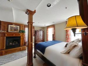 a bedroom with a bed with a lamp and a fireplace at The Port Hotel in Port Washington