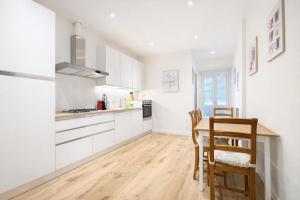 a kitchen with white cabinets and a wooden table at Casa Camelia in Scarperia