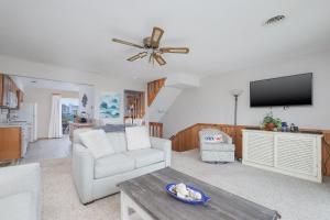 a living room with a couch and a ceiling fan at 4209 - Moby Duck in Duck +26 photos