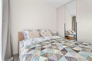 a bedroom with a bed with a quilt on it at MDM Apartments in Gdańsk