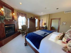a bedroom with a large bed and a fireplace at The Port Hotel in Port Washington