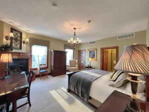 a bedroom with a bed and a desk and a fireplace at The Port Hotel in Port Washington