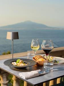 a table with two plates of food and wine glasses at Hotel Villa Garden in Sant'Agnello