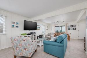 a living room with two chairs and a tv at 5061 - Good Night Irene in Kill Devil Hills
