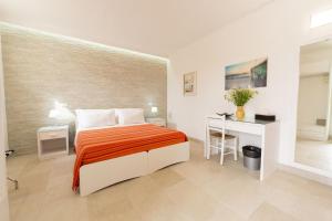 a bedroom with a bed and a desk in it at Masseria Un Posto al Sole in Otranto +88 photos
