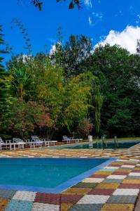 a swimming pool in a park with trees at Chic Modern Studio Apartment with Pool in Nanyuki