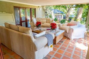 a living room with couches and a table at Shepherd's Corner Guest House - Tranquil Boutique Stay in Bryanston in Johannesburg