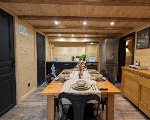 a dining room with a table in a kitchen at La Clochette d'Hiver Familial et espace Détente in Cornimont +14 photos