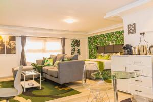 a living room with a couch and a table at Chic Modern Studio Apartment with Pool in Nanyuki