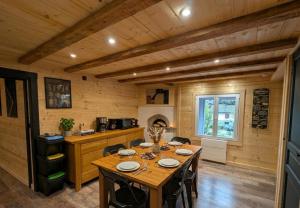 a dining room with a table and a kitchen at La Clochette d'Hiver Familial et espace Détente in Cornimont
