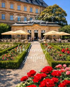 a garden with red roses in front of a building at Friends & Family Olymp in Bamberg
