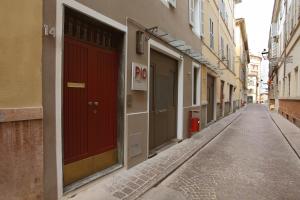 an empty alley way with red doors and buildings at PIO Rooms b&b Parma in Parma