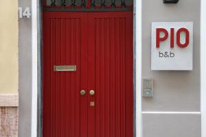 a red door on a house with a sign on it at PIO Rooms b&b Parma in Parma