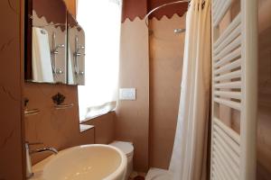 a bathroom with a sink and a toilet and a mirror at PIO Rooms b&b Parma in Parma