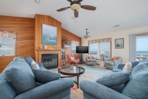 a living room with blue couches and a fireplace at 5437 - WeekAway in Nags Head