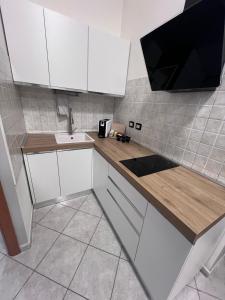 a kitchen with white cabinets and a sink at NoveQuattro Apartment in Cagliari