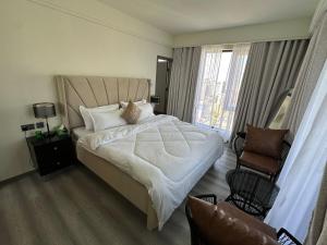 a bedroom with a large bed and a chair at The Nairobi Experience in Nairobi +47 photos
